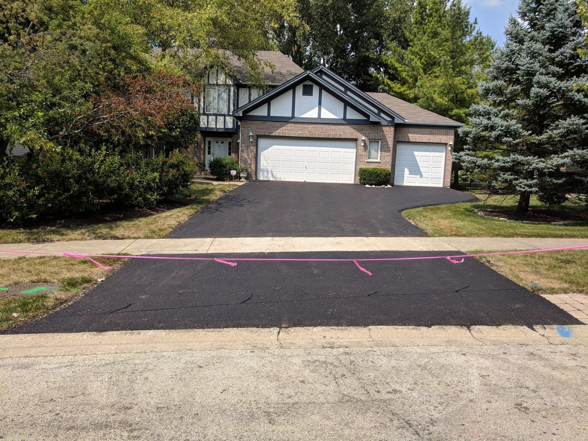 A driveway is being paved in front of a house.