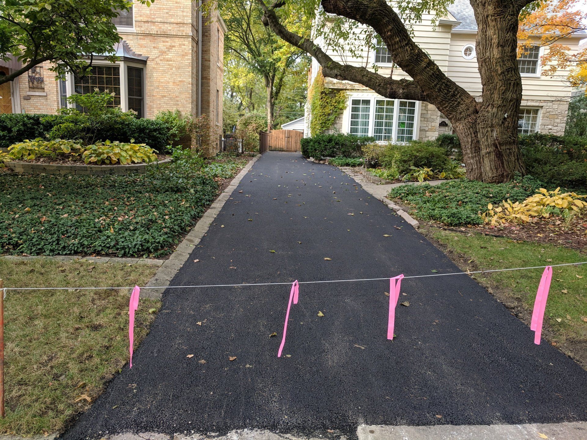 A driveway with a brick walkway and curb