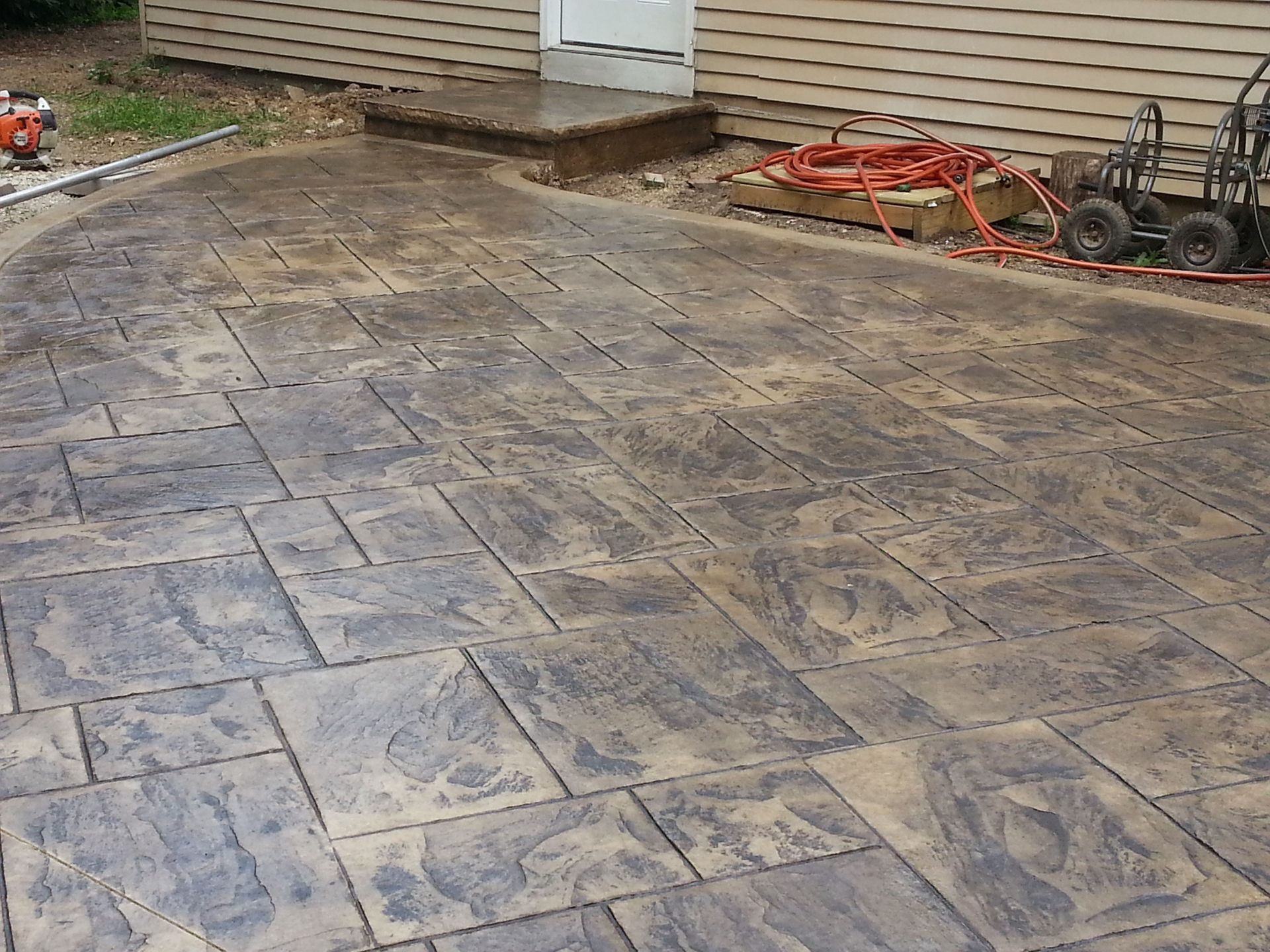 A concrete driveway is being built in front of a house.