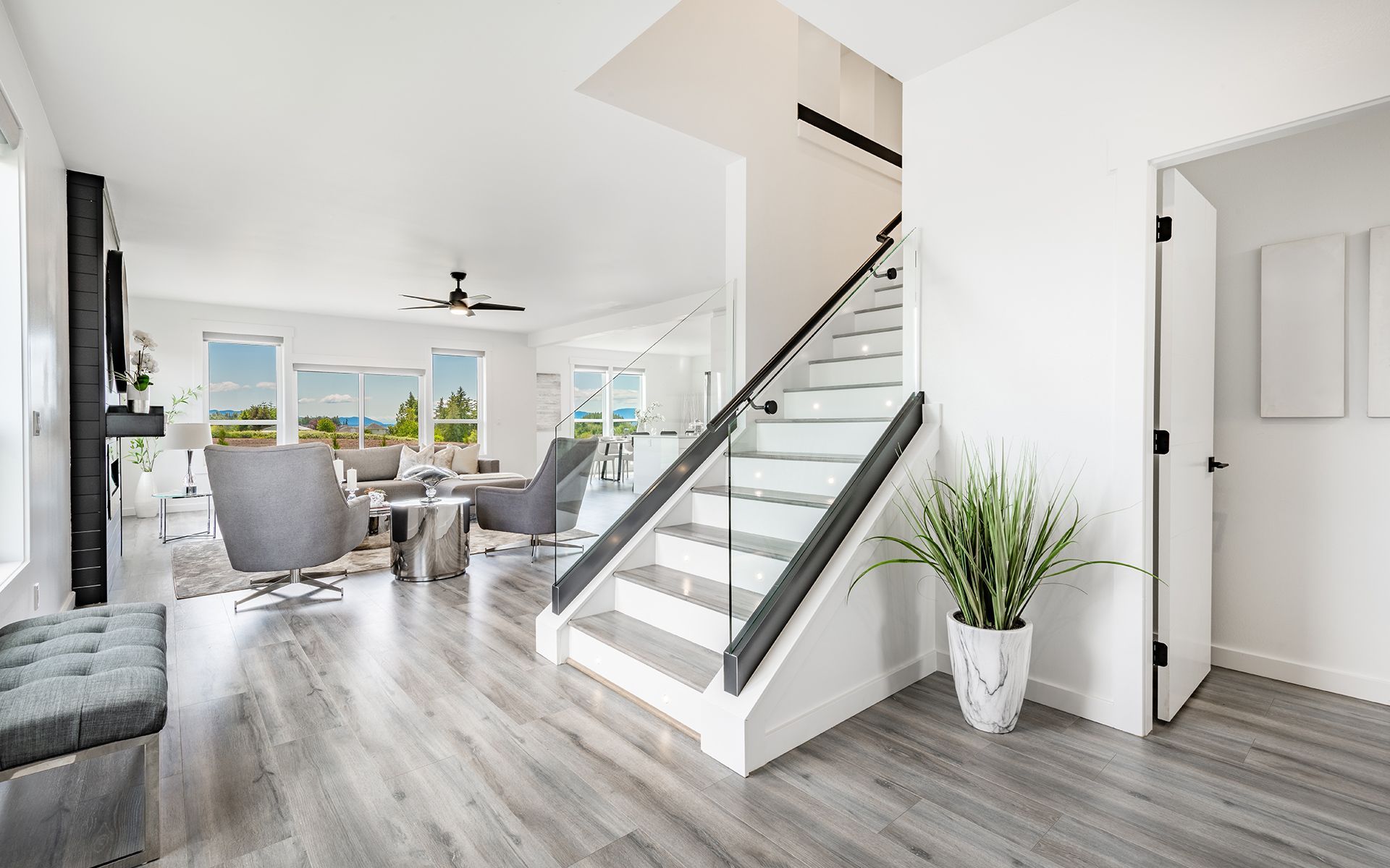 Modern home interior with a staircase, living room, and entryway.