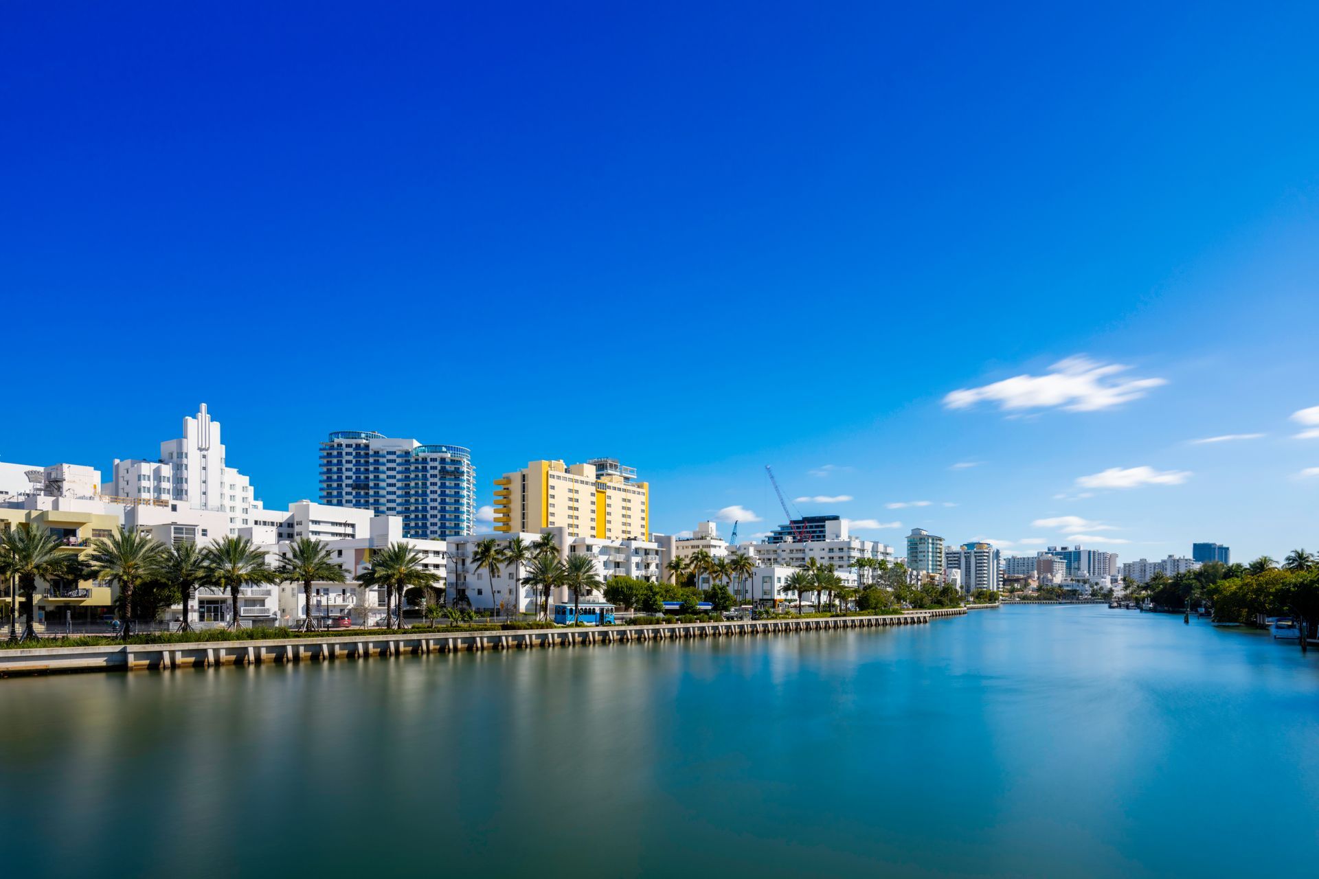 A waterfront cityscape featuring a calm body of water under a clear blue sky. A waterfront cityscape featuring a calm body of water under a clear blue sky.