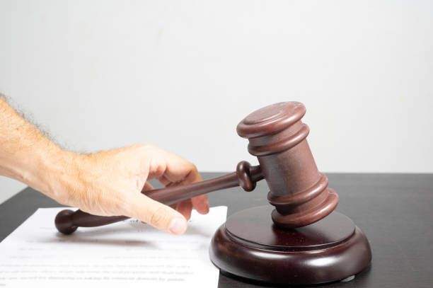 Hand with gavel and document symbolizes Social Security Disability attorney court ruling process.