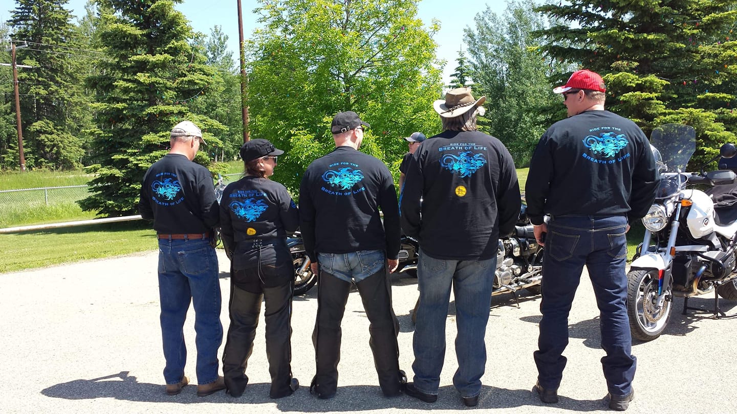 5 ride participants faced backwards showing off shirts