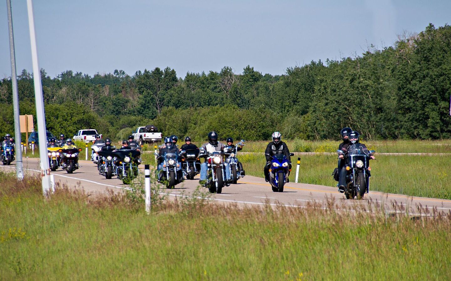 group of motorcyclists driving down the road