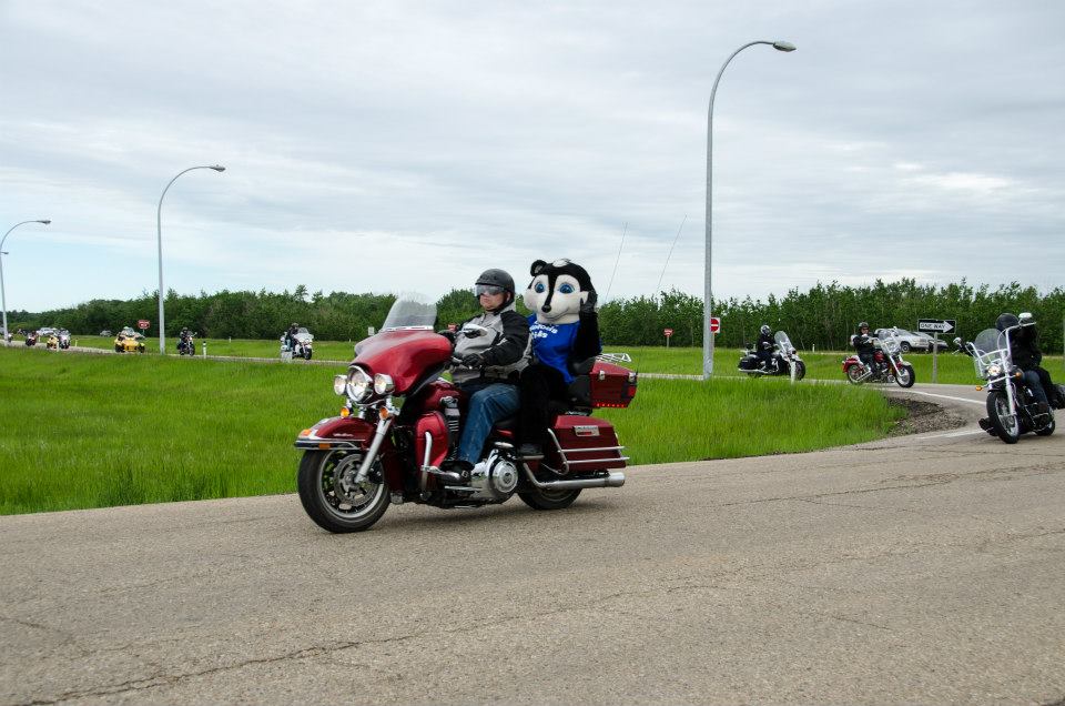 ride participants, and mascot pictured on a motorcycle