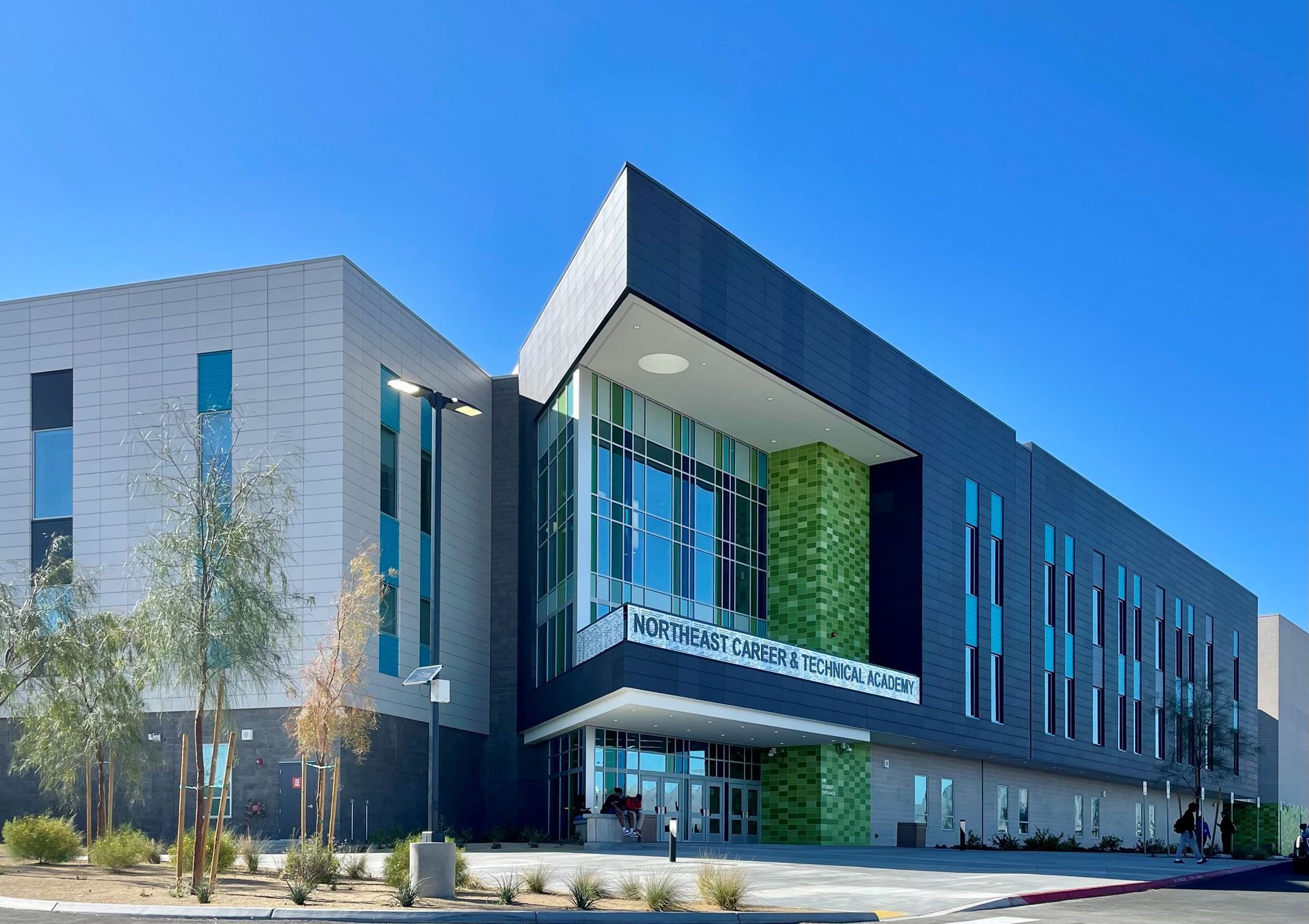 A large building with a lot of windows and trees in front of it.