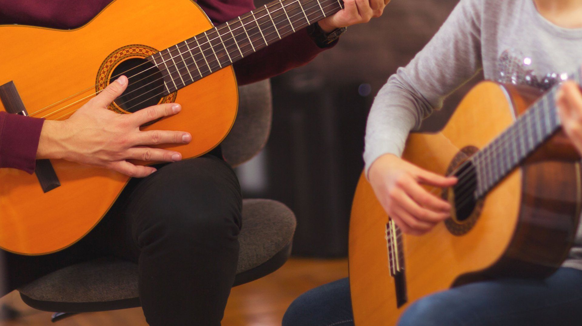 A man and a woman are playing guitars together.