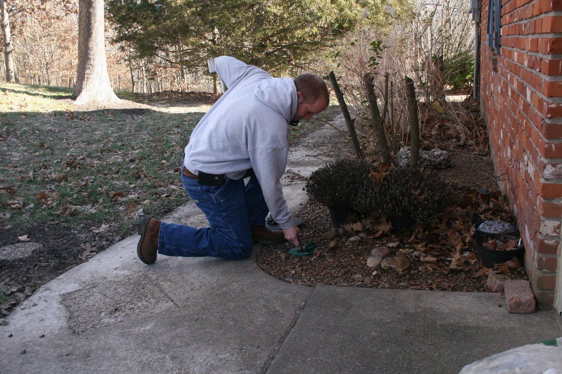 Man checking the ground — Jefferson City, MO — Art’s Pest Control