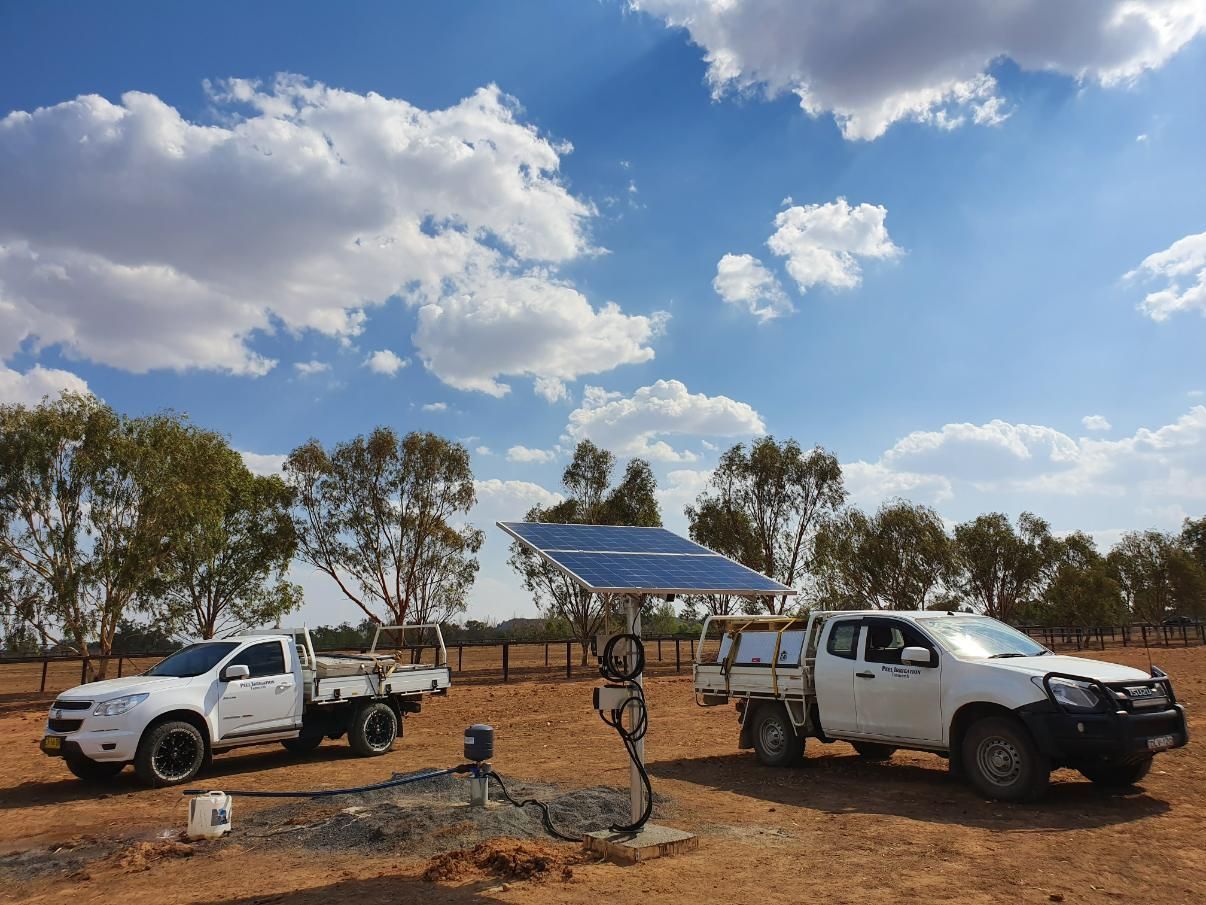 Two White Trucks Are Parked Next to Each Other in a Dirt Field — Peel Irrigation & Water Supplies in Taminda, NSW
