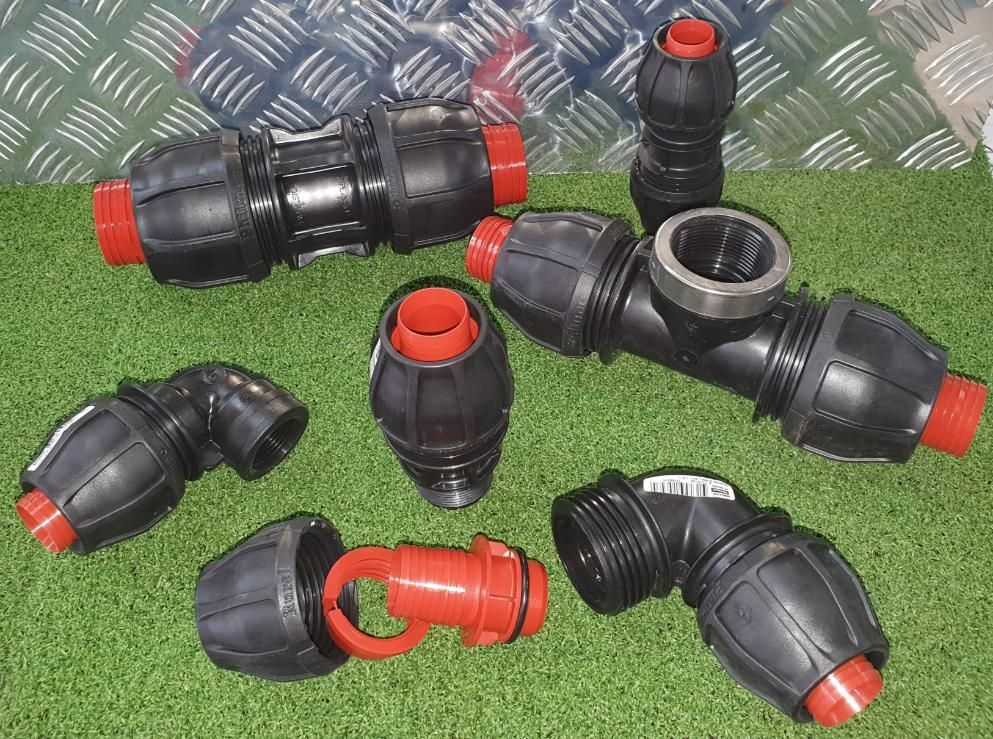 Bunch of Plastic Pipe Fittings Are Laying on the Grass — Peel Irrigation & Water Supplies in Gunnedah, NSW