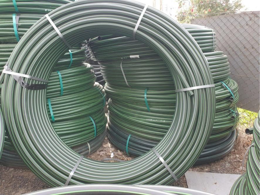 Bunch of Green Plastic Pipes Are Stacked on Top of Each Other — Peel Irrigation & Water Supplies in Gunnedah, NSW
