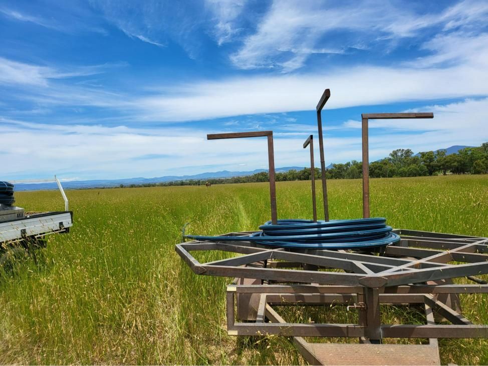 Hose Reel is Sitting in the Middle of a Grassy Field — Peel Irrigation & Water Supplies in Taminda, NSW