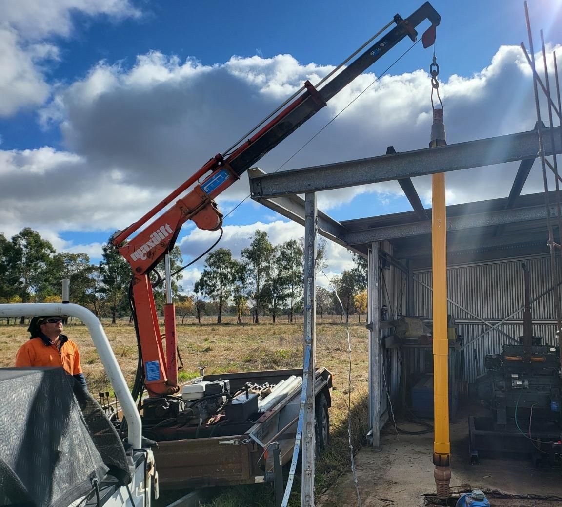 Man is Standing Next to a Truck With a Crane Attached to It — Peel Irrigation & Water Supplies in Taminda, NSW