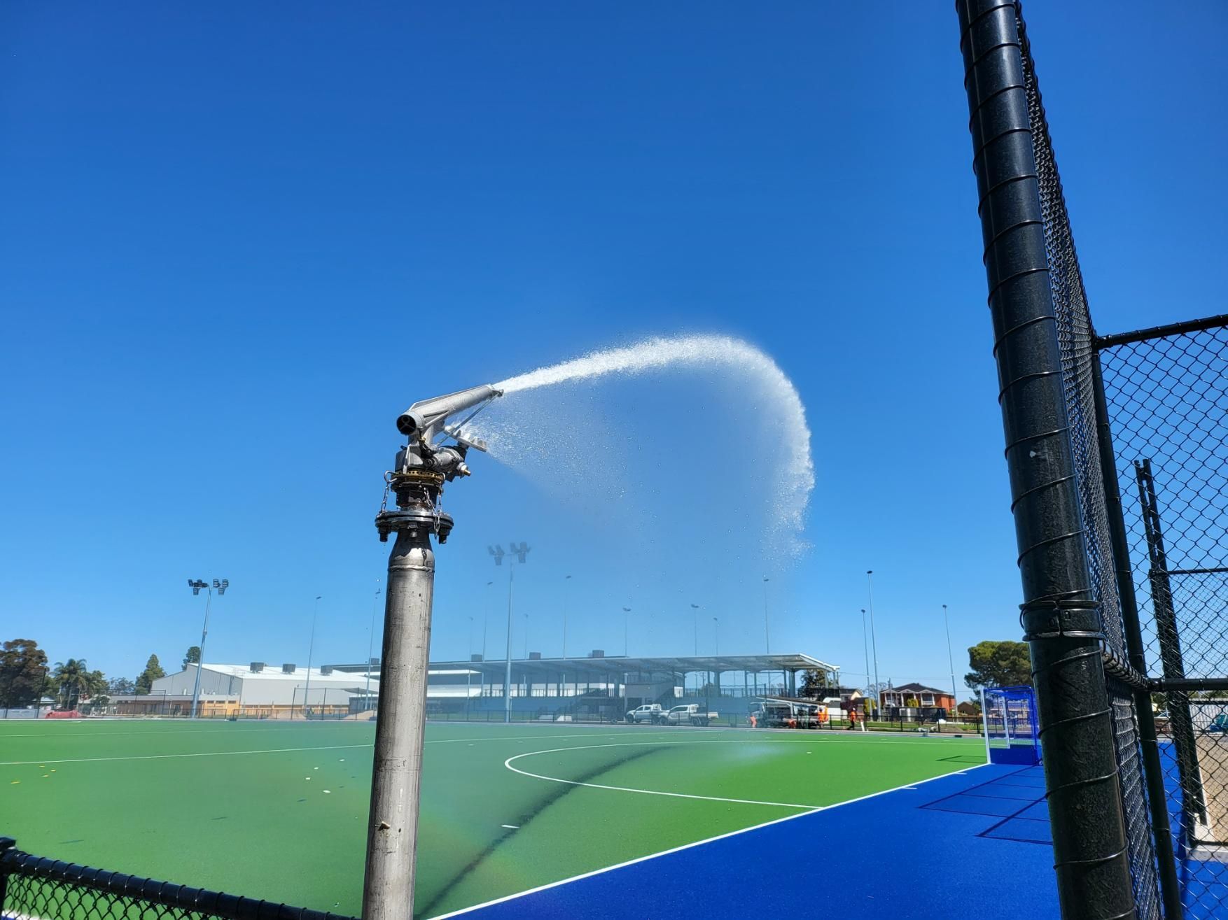 Hose is Spraying Water on a Tennis Court — Peel Irrigation & Water Supplies in Narrabri, NSW