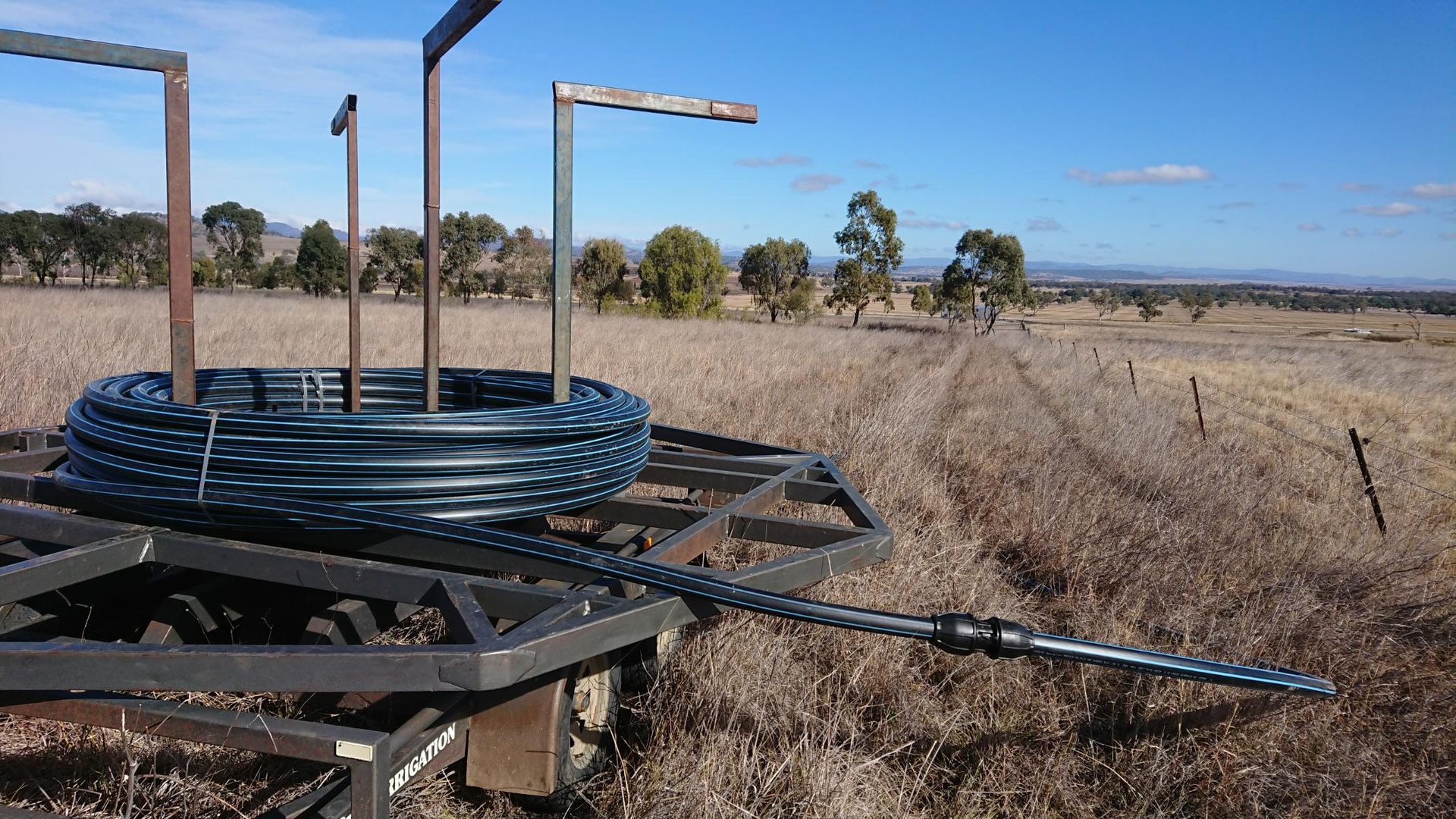 Spool of Wire is Sitting on Top of a Trailer in a Field — Peel Irrigation & Water Supplies in Taminda, NSW