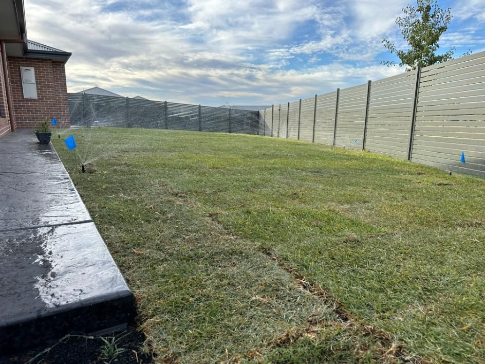 Lawn With a Fence and a Sprinkler in the Backyard of a House — Peel Irrigation & Water Supplies in Taminda, NSW