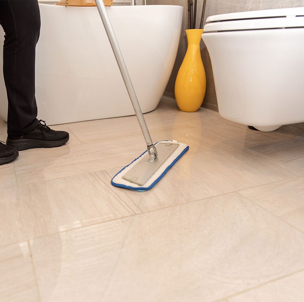 a member of the sparkling green team cleaning the bathroom of the office