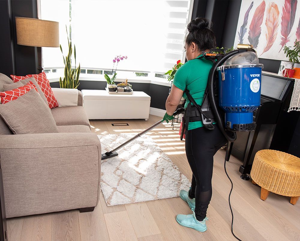 a member of the sparkling green team cleaning the living room