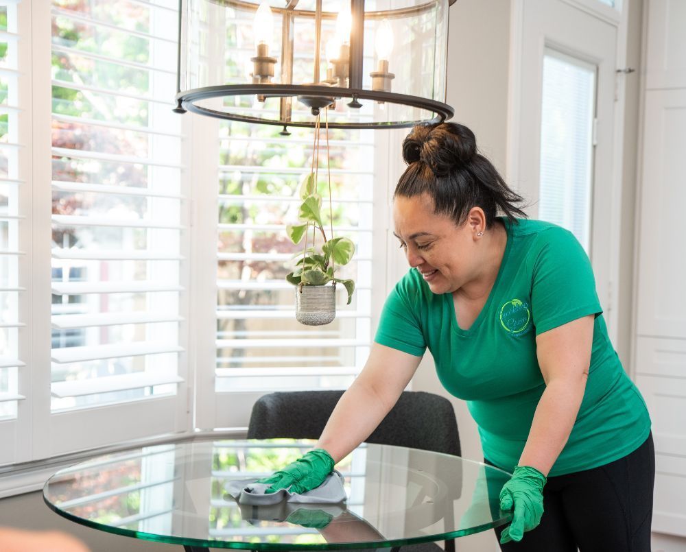 a member of the sparkling green team cleaning the table of the house