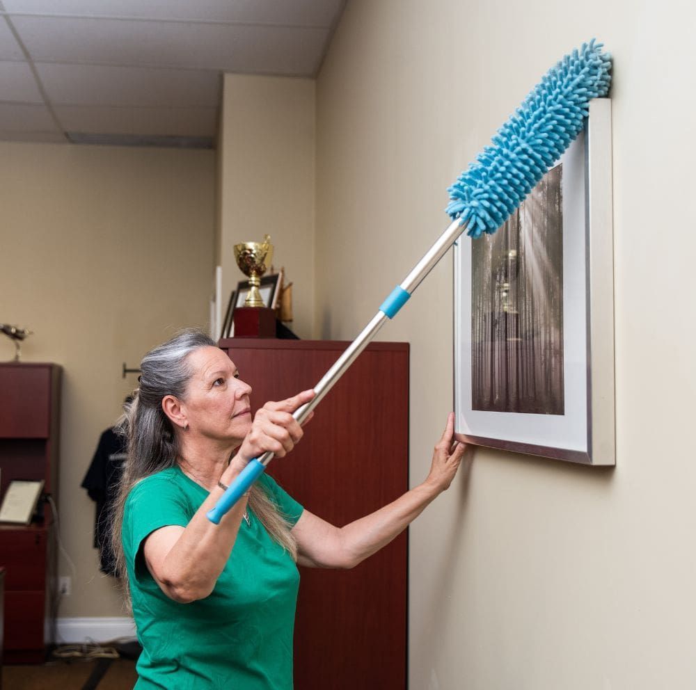 a member of the sparkling green team cleaning the surface of the office