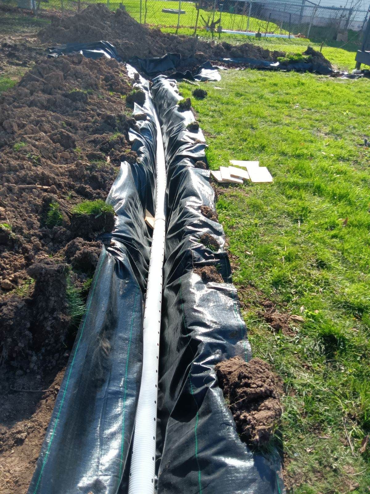 A pipe is laying in the dirt in a field.