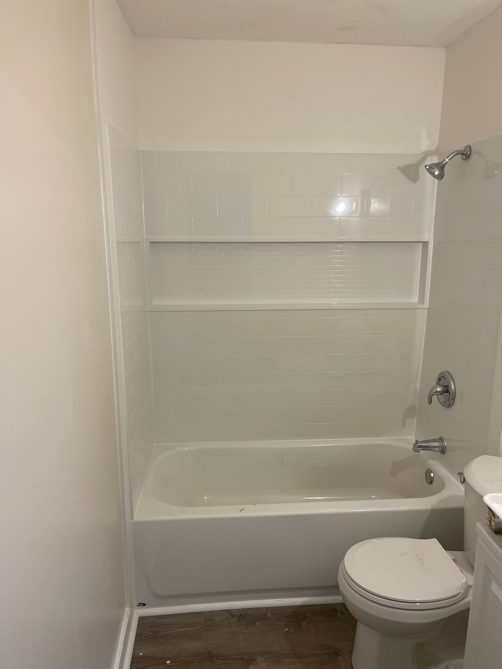 A bathroom with a bathtub , toilet and shower.