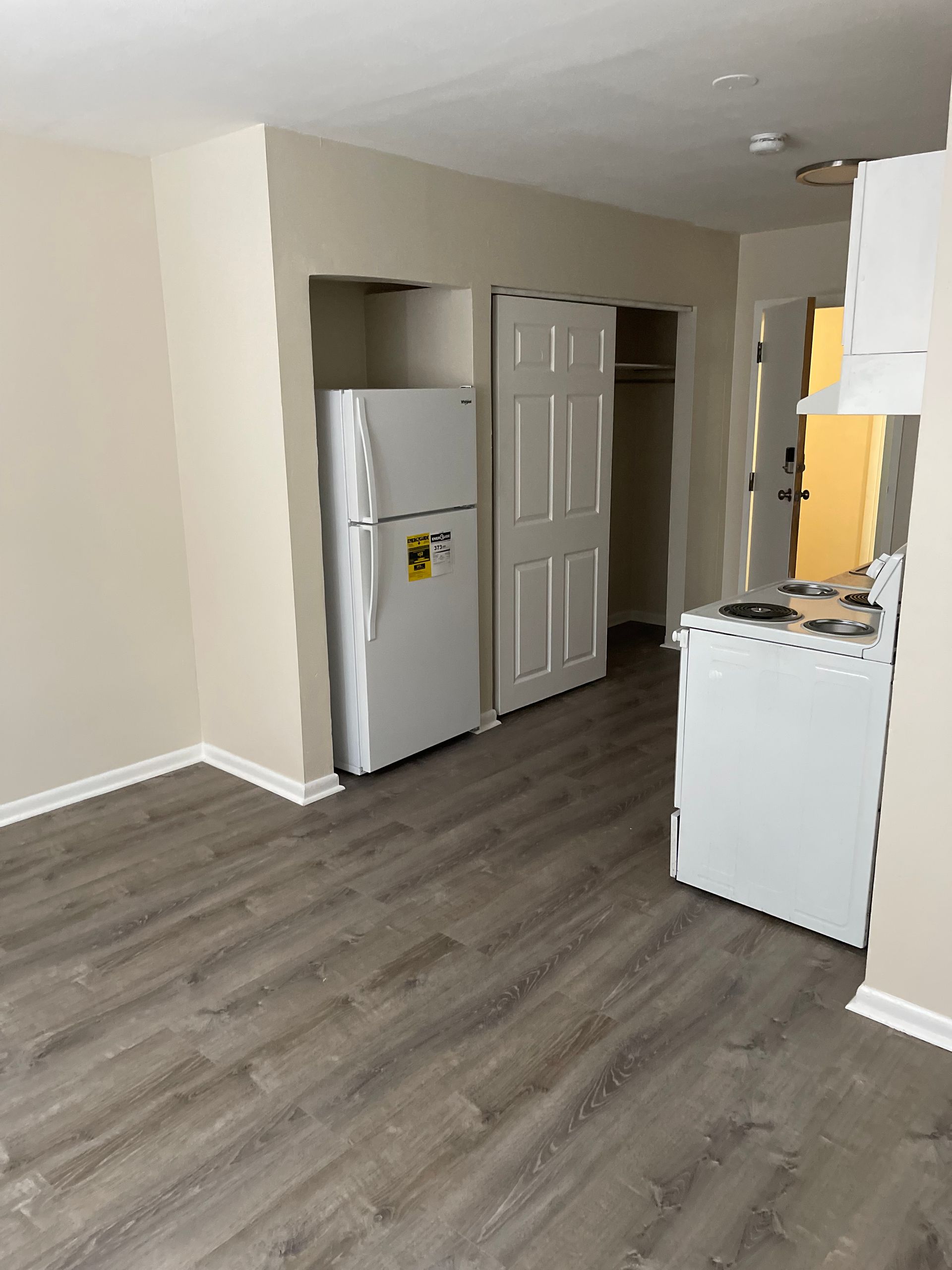 There is a refrigerator and a stove in the room.