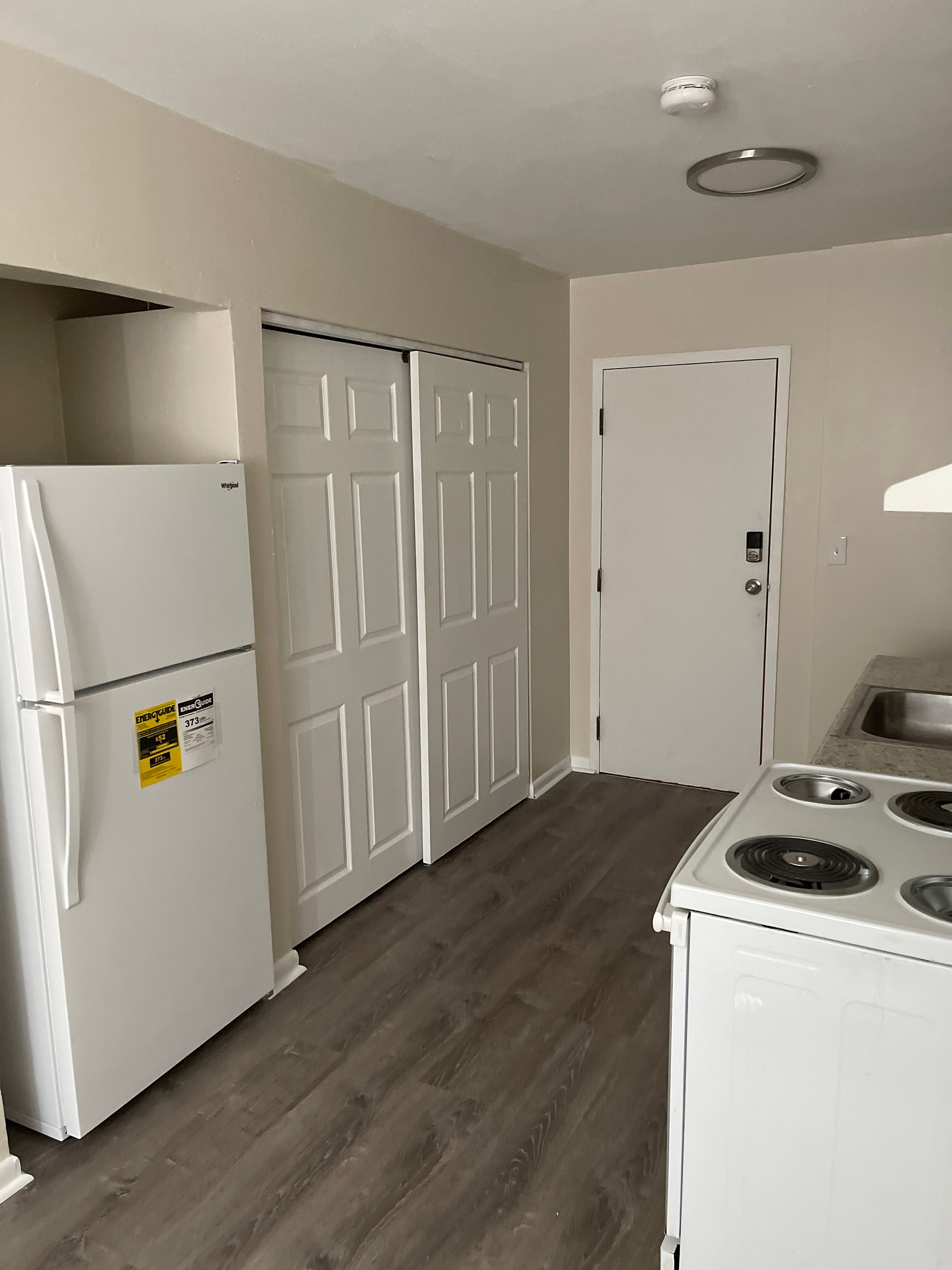 A kitchen with a refrigerator , stove and sink.