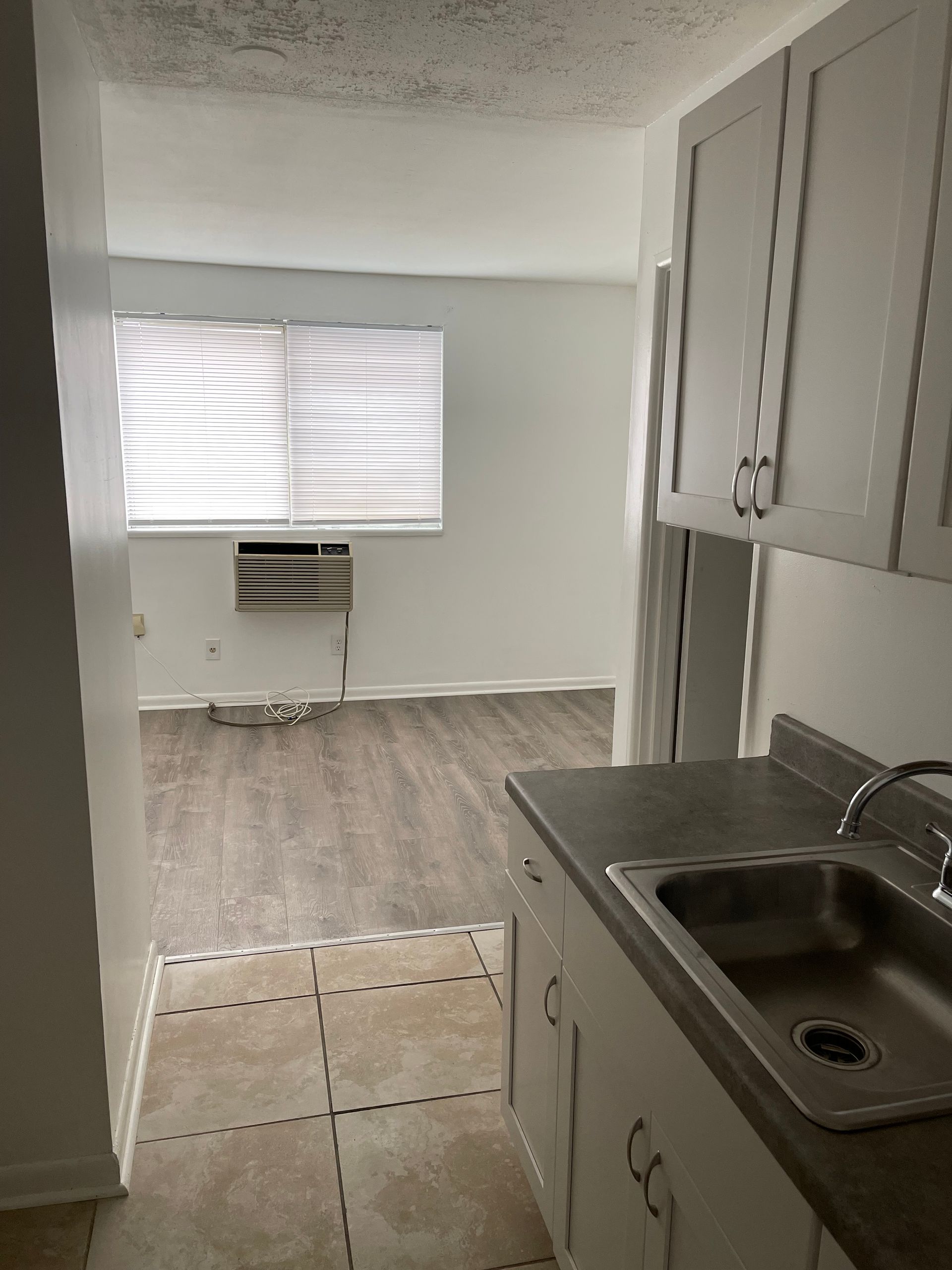 A kitchen with a sink , cabinets and a window