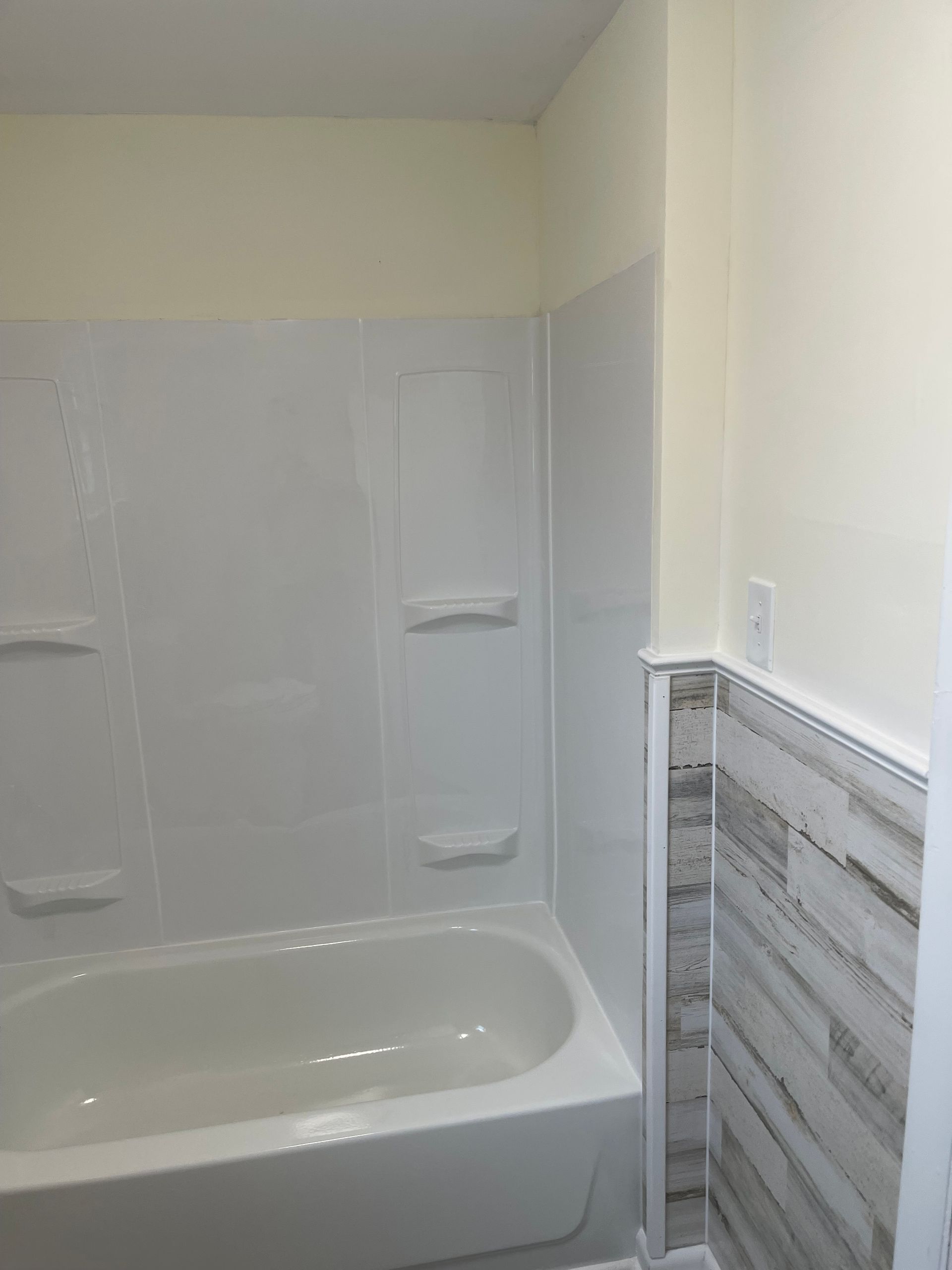 A bathroom with a bathtub and a shower stall.