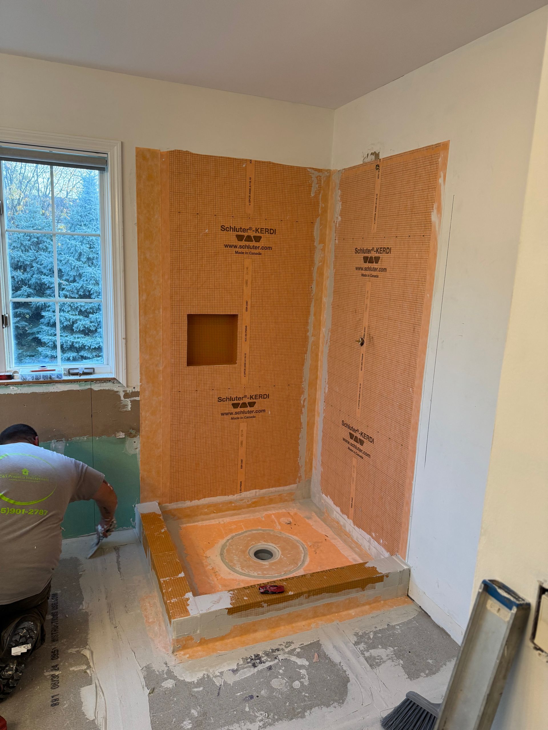 A man is working on a shower in a bathroom.