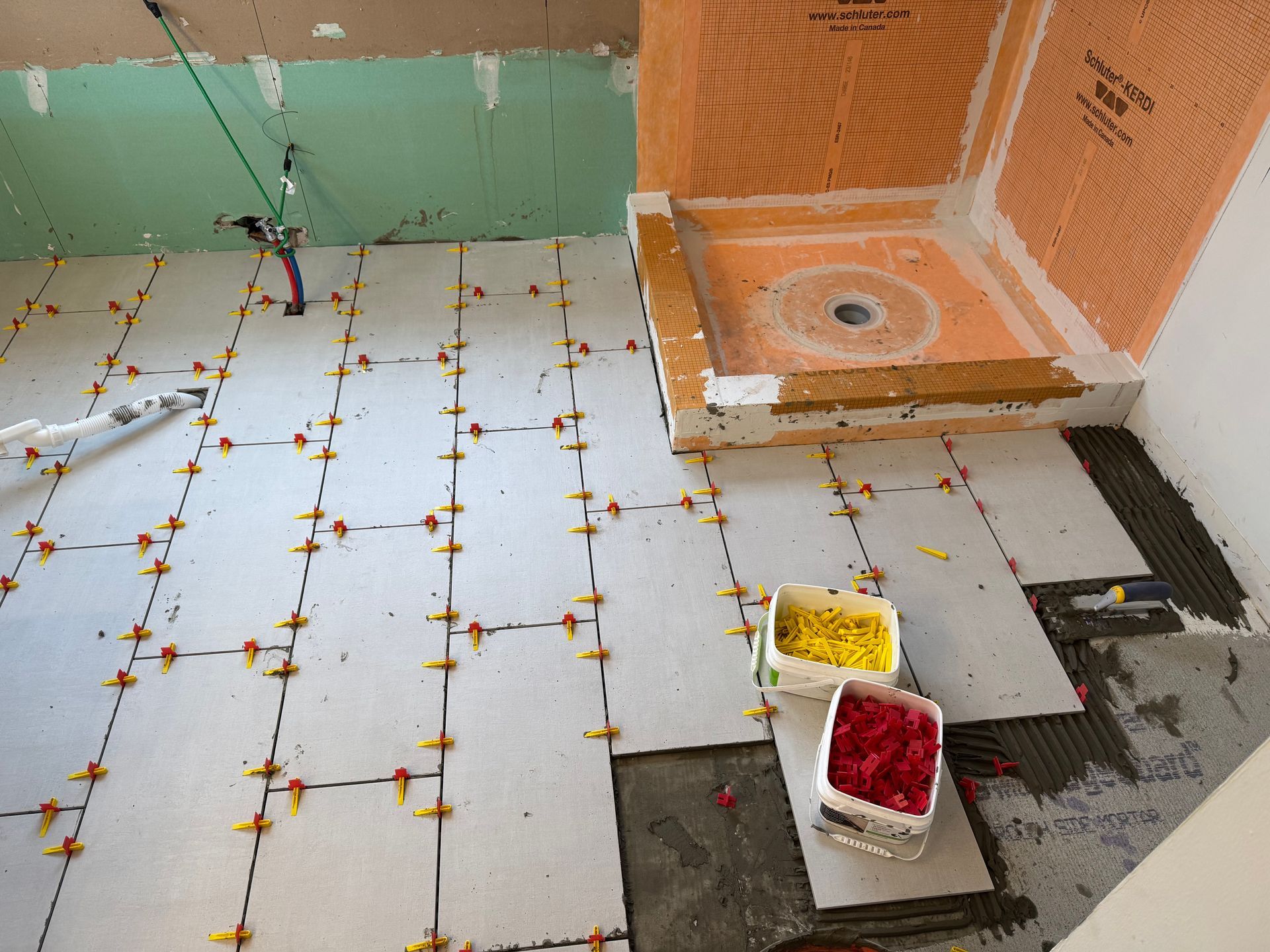 A bathroom is being remodeled with tiles and a shower stall.