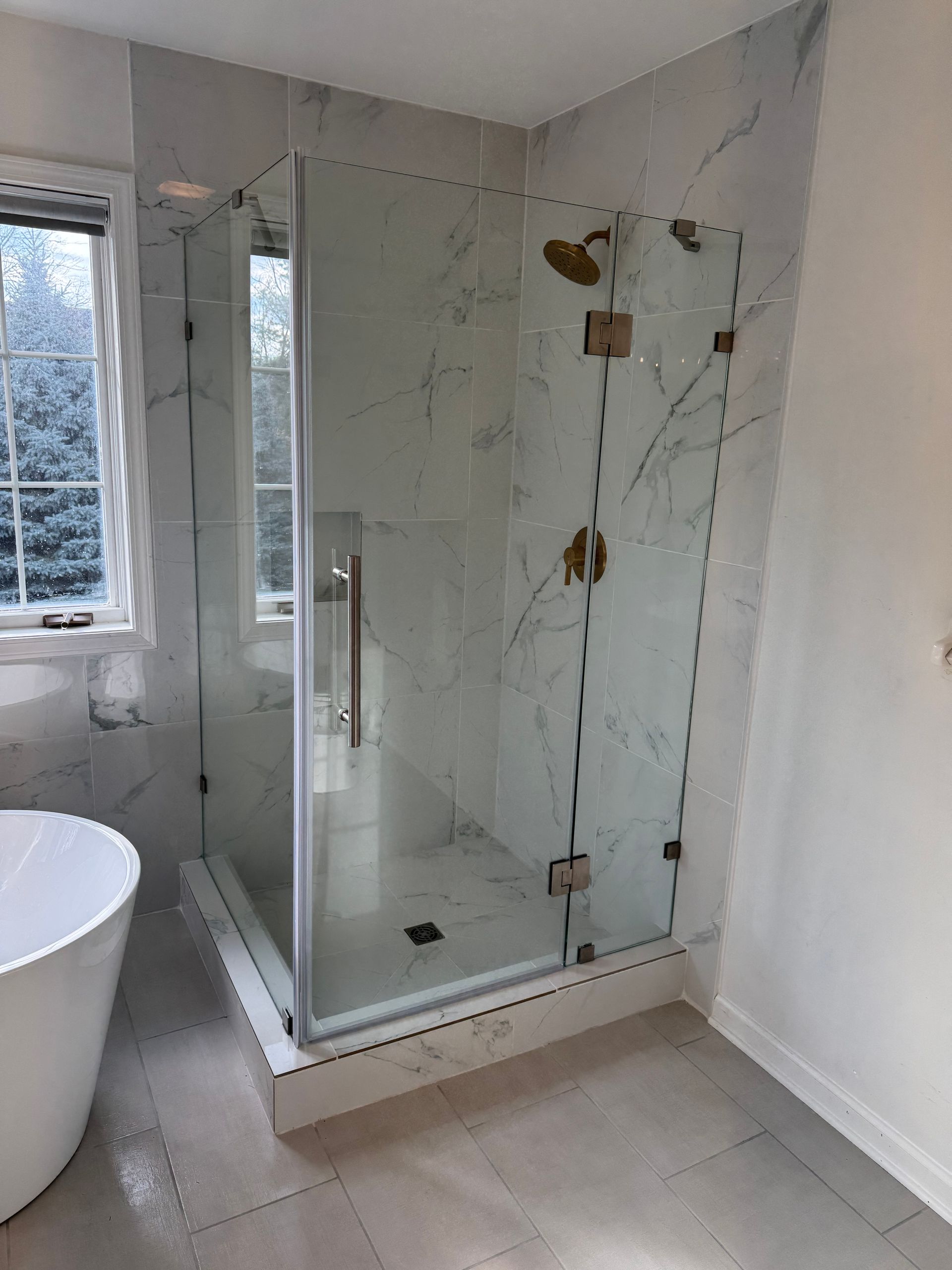 A bathroom with a walk in shower and a bathtub.