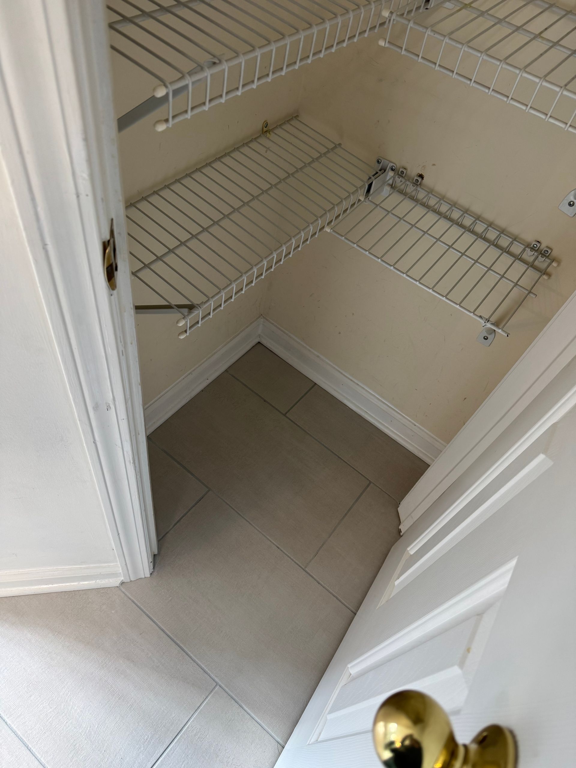 A closet with shelves and a door handle