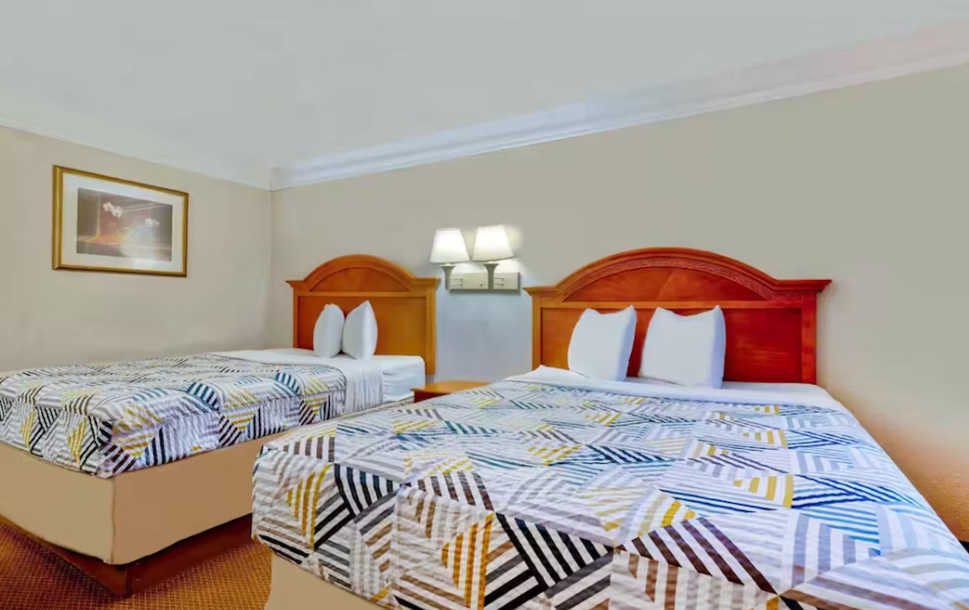 Una habitación de hotel con dos camas y dos lámparas.