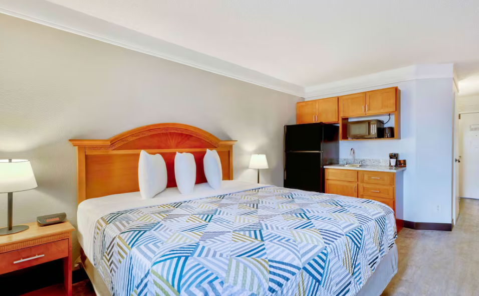 Una habitación de hotel con una cama king size y una cocina.