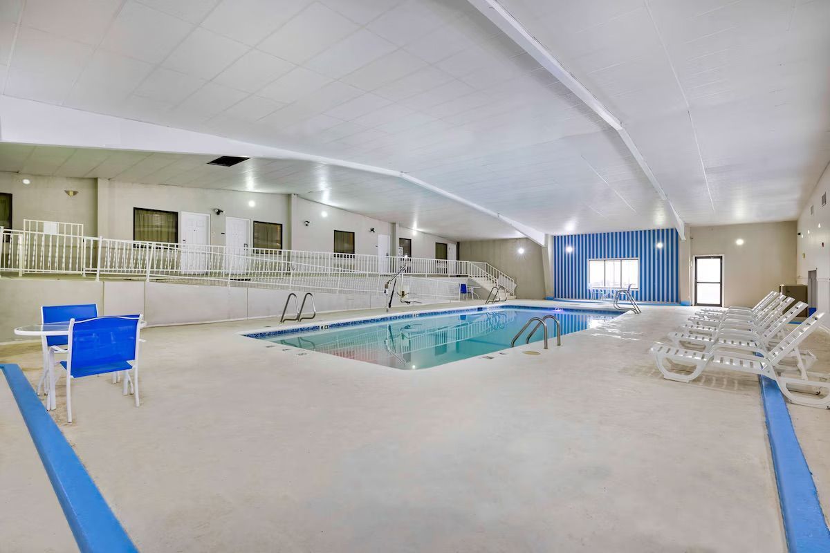 Una gran piscina cubierta con sillas y mesas en un hotel.