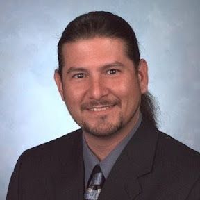 A man in a suit and tie is smiling for the camera.