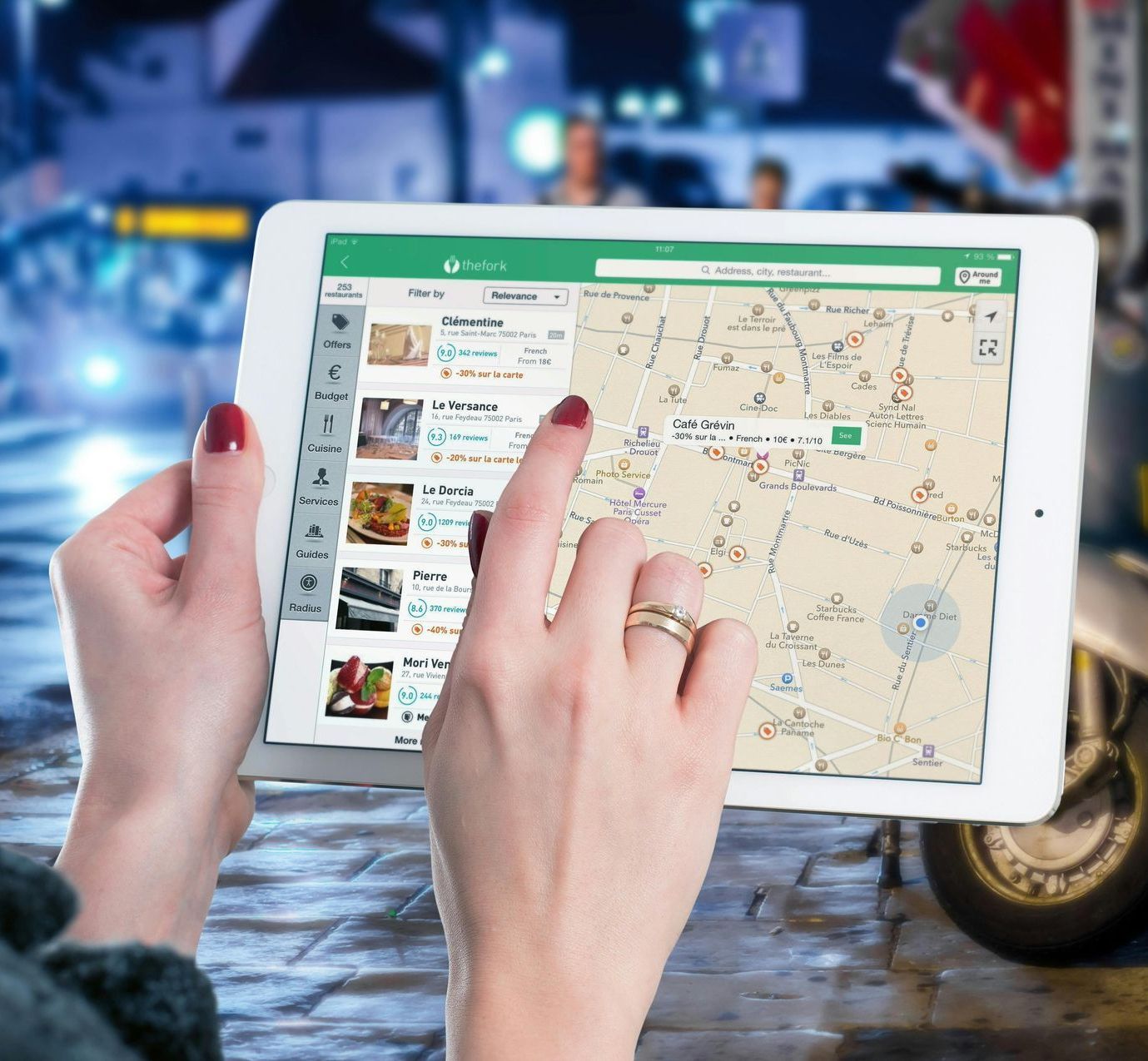 A person is holding a tablet with a map on it