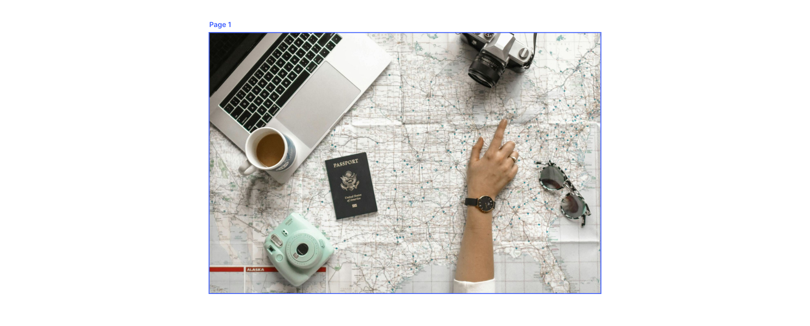 map with camera, laptop, coffee and passport on top