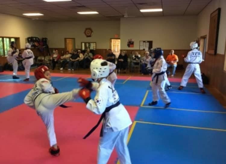 A person is holding a sparkler in their hand in the dark.