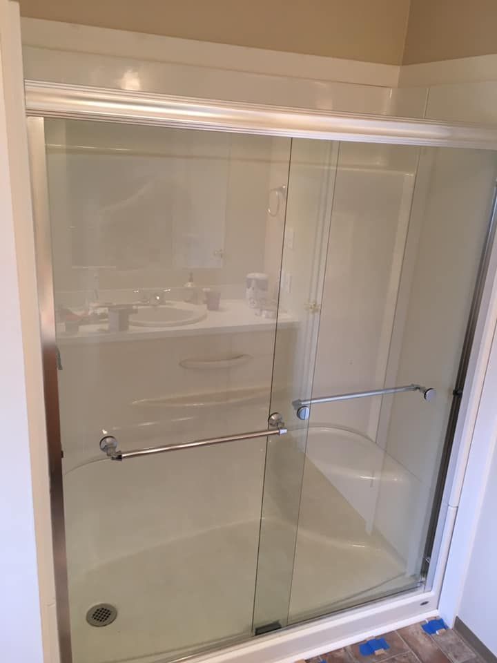 White shower stall with sliding glass doors and chrome handles.