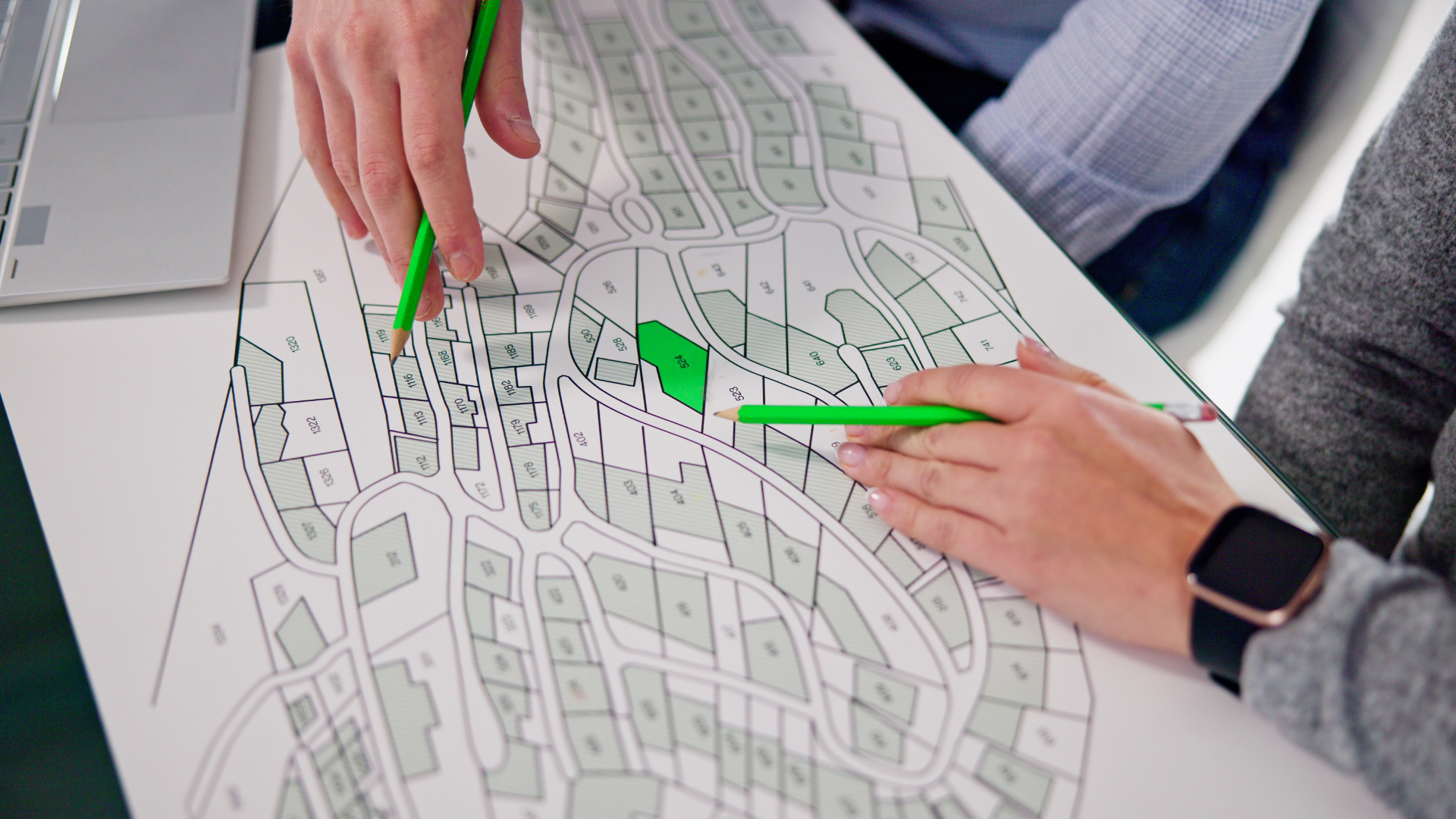 A group of people are sitting at a table looking at a map.