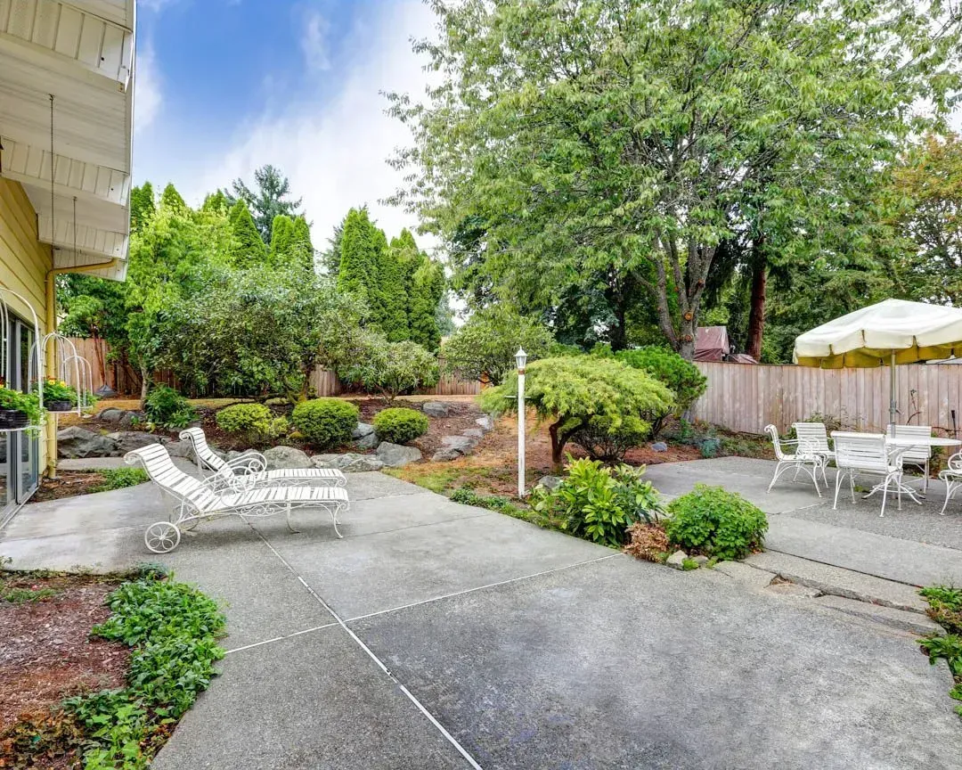 A man is using a broom to spread concrete on a sidewalk