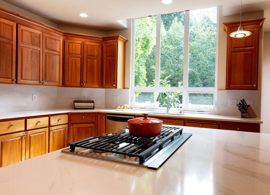 A kitchen with wooden cabinets and a pot on the stove