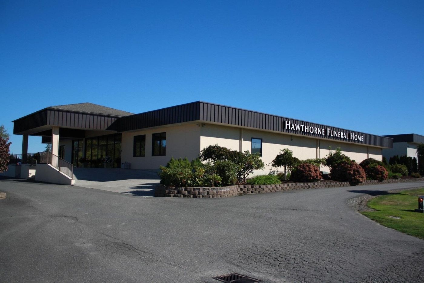 Hawthorne Funeral Home exterior, tan building, dark roof, sunny day.