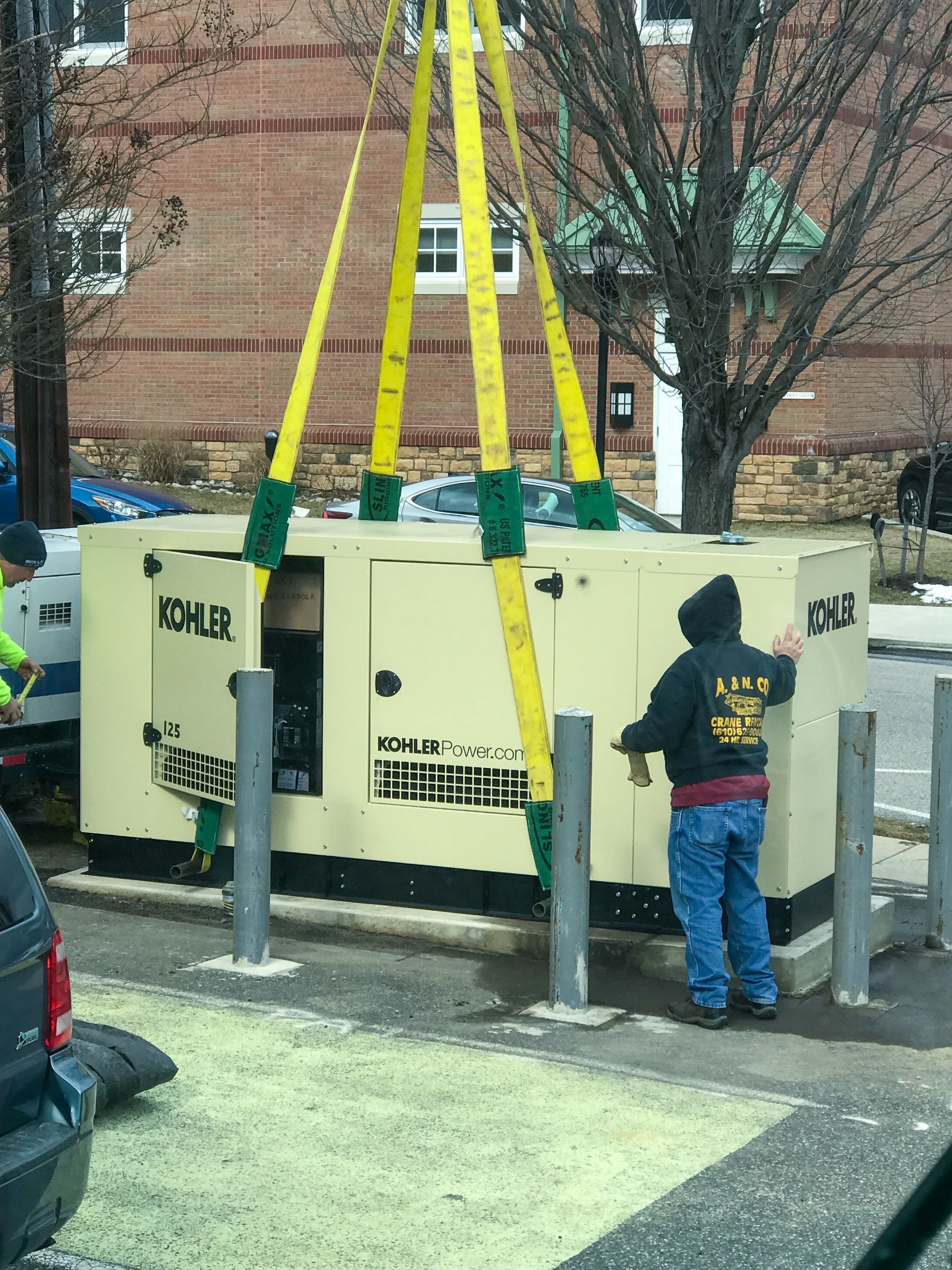 A Kohler generator is being lifted by a crane from A&N Crane Rental. 