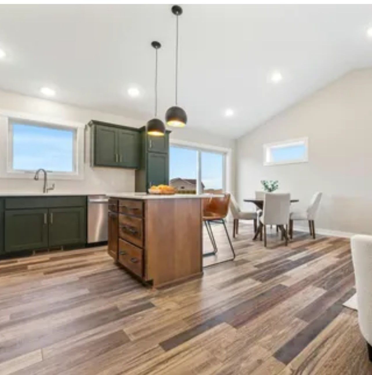 A kitchen with stainless steel appliances and wooden floors
