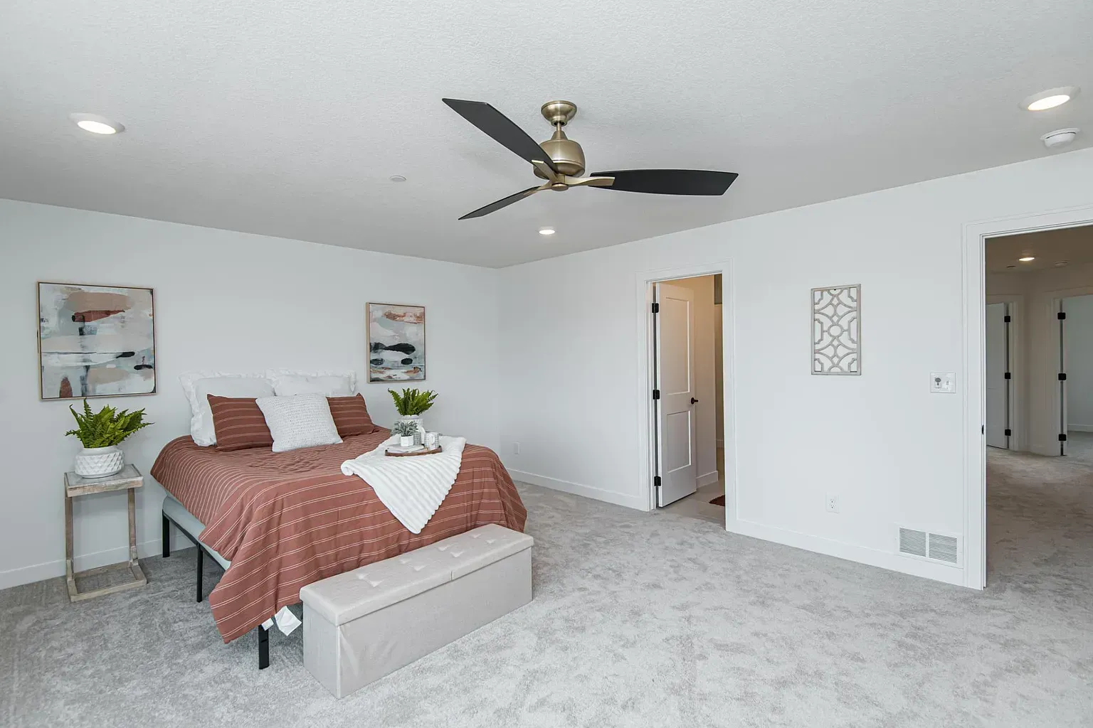 A bedroom with a bed and a ceiling fan.