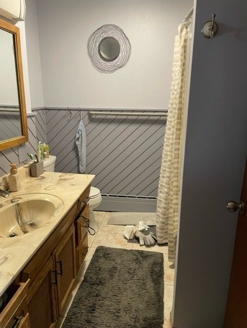 Bathroom with gray walls, beige countertop, and a dark gray rug.